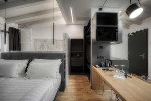 a bedroom with a bed and a desk with a television at M Loft - adults only in Malcesine