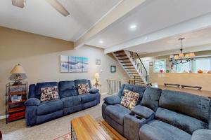 a living room with two blue couches and a staircase at Stella's Retreat in McHenry