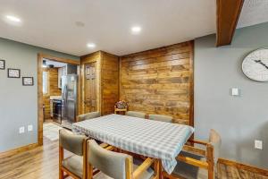 a dining room with a table and chairs and a clock at Ski Cove #2 in McHenry