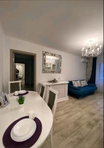a dining room with a white table and a blue couch at Центр Пассаж ЦУМ in Dnipro +4 photos