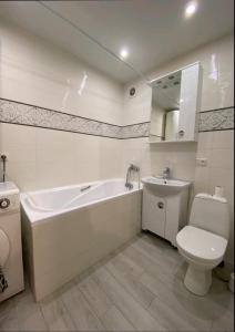 a bathroom with a tub and a toilet and a sink at Центр Пассаж ЦУМ in Dnipro