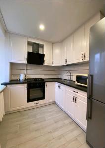 a kitchen with white cabinets and a refrigerator at Центр Пассаж ЦУМ in Dnipro