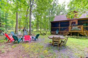 a group of chairs and tables in front of a log cabin at Lazy Bear Lodge in Swanton