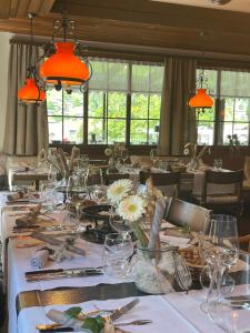a dining room with a long table with white tablecloths at Gasthof Tenne - Ferie mit Härz in Lenk