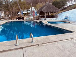 a large swimming pool with a gazebo at Bungalows El Mirador in Cruz de Huanacaxtle