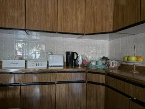 a kitchen with wooden cabinets and a counter top with fruit at Casa di Nonna Vanda in Sestu