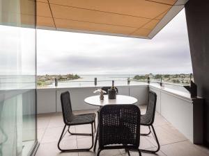 a table and chairs on a balcony with a view at Novotel Devonport in Devonport