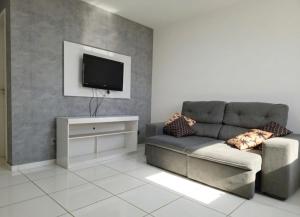 a living room with a couch and a flat screen tv at Apartamento Moto Chico Petrolina in Petrolina