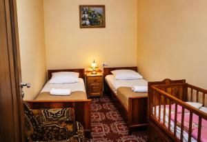 a small room with two beds and a crib at Hayi Tun Guest House in Goris