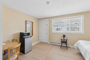 a bedroom with a bed and a table and a microwave at The Inn at Soho Square in Old Orchard Beach