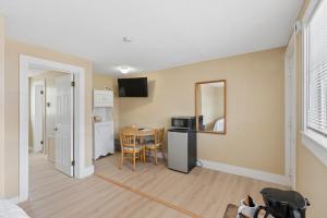 a kitchen and dining room with a table and a mirror at The Inn at Soho Square in Old Orchard Beach