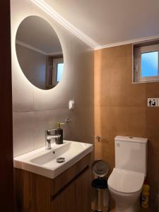 a bathroom with a sink and a toilet with a mirror at Olea House in Alexandroupoli +11 photos