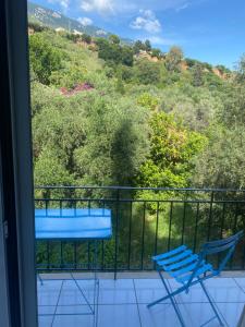 a balcony with two chairs and a view of a mountain at Trifilli in Lourdata