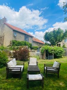 a group of chairs and a table in a yard at Gîte La Vie Verte - Gîte charmant 3 etoiles classé Meublé de Tourisme in Saint-Domet