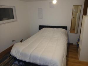 a bedroom with a bed with a white comforter at Chez vous in Dirinon