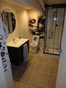 a bathroom with a toilet and a sink and a shower at Chez vous in Dirinon