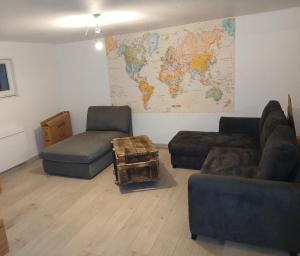 a living room with couches and a map of the world at Chez vous in Dirinon