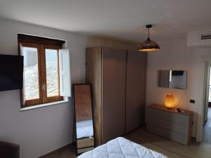 a bedroom with a bed and a dresser and a mirror at B&B Vuiariello in Montefusco