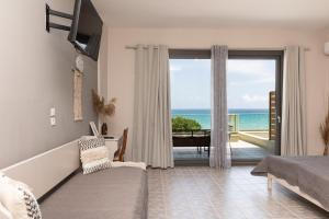 a living room with a couch and a view of the ocean at Kastalia Studios And APARTMENTS in Skala Potamias +13 photos