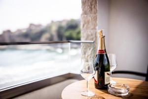 Eine Flasche Champagner und zwei Gläser auf einem Tisch in der Unterkunft Emaar in Ulcinj + 26 Fotos