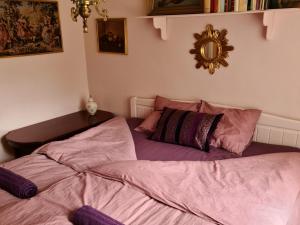 a bedroom with two beds and a mirror on the wall at Artist eremitage Leonora - Historic schoolhouse apartment in Fjälkinge