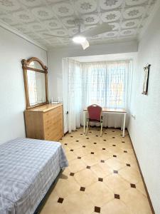 a bedroom with a bed and a desk and a mirror at Casa Carlos de Novelda in Novelda +6 photos