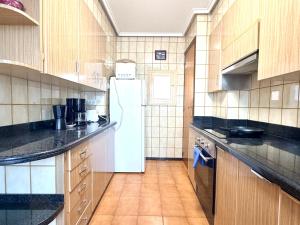 a large kitchen with a white refrigerator in it at Casa Carlos de Novelda in Novelda