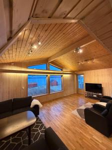 a living room with a couch and a tv at Oldervik Sea House in Tromsø