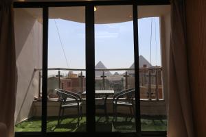 a view of a balcony with two chairs and a table at Sacred Pyramids Stay in Cairo