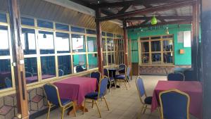 a restaurant with two tables and chairs and windows at Life Vision Hotel in Huye