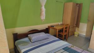 a room with a bed and a table and a desk at Life Vision Hotel in Huye
