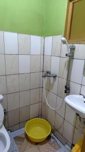 a bathroom with a yellow toilet and a shower at Life Vision Hotel in Huye