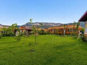 a green yard with trees in the middle of it at Izgen Bungalows in Cıralı