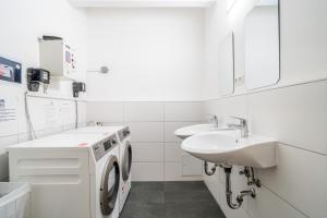 a white bathroom with a washing machine and a sink at D10 I shared bathrooms&kitchen in Garching bei München