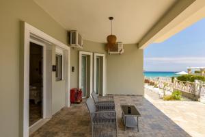 a patio with chairs and a table and the ocean at Kastalia Studios And APARTMENTS in Skala Potamias