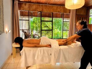 a woman giving a woman a massage on a bed at CasaBosque in Tarapoto