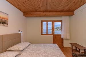 a bedroom with a bed and a window at Apartments Steps from the Sea in Donja Klada