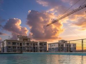 a building with a crane in front of the water at EM Homes Modern 1-Bedroom Apartment with Pool 15 Minutes from JKIA Airport in Marimbeti