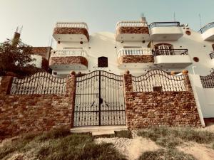 a house with a gate and a brick wall at private studio - djorff area in Al Aqālitah