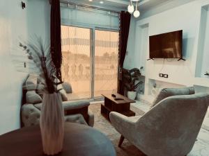 a living room with two couches and a tv at private studio - djorff area in Al Aqālitah