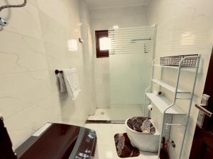 a white bathroom with a sink and a shower at private studio - djorff area in Al Aqālitah