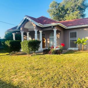 a small house with a lawn in front of it at BJ&T Vacation Homes in Kasane
