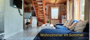 a living room with a blue couch and a staircase at Ruhiges Elbhäuschen nahe Hamburg in Hollern-Twielenfleth