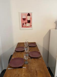 un tavolo di legno con piatti e bicchieri da vino sopra di Ciotat Cherry - au coeur de La Ciotat à 2 pas du port a La Ciotat