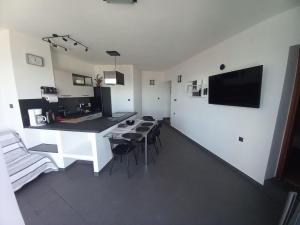 a living room with a kitchen and a table and chairs at Apartman Lili in Malinska