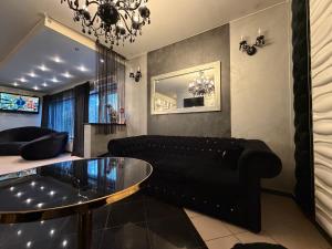 a living room with a black couch and a glass table at Glow Rooms in Gdynia