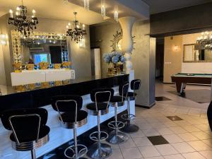 a bar with black stools and a pool table at Glow Rooms in Gdynia +49 photos