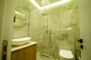 a bathroom with a shower and a toilet and a sink at Hotel Sanremo Vlore in Vlorë +46 photos