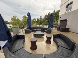 a patio with couches and tables and blue umbrellas at Glow Rooms in Gdynia