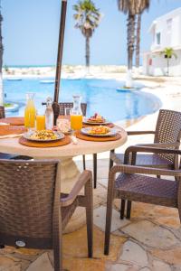 a table with plates of food and orange juice at HOTEL CARASOL VILLAS & SUITES in Ciudad Madero